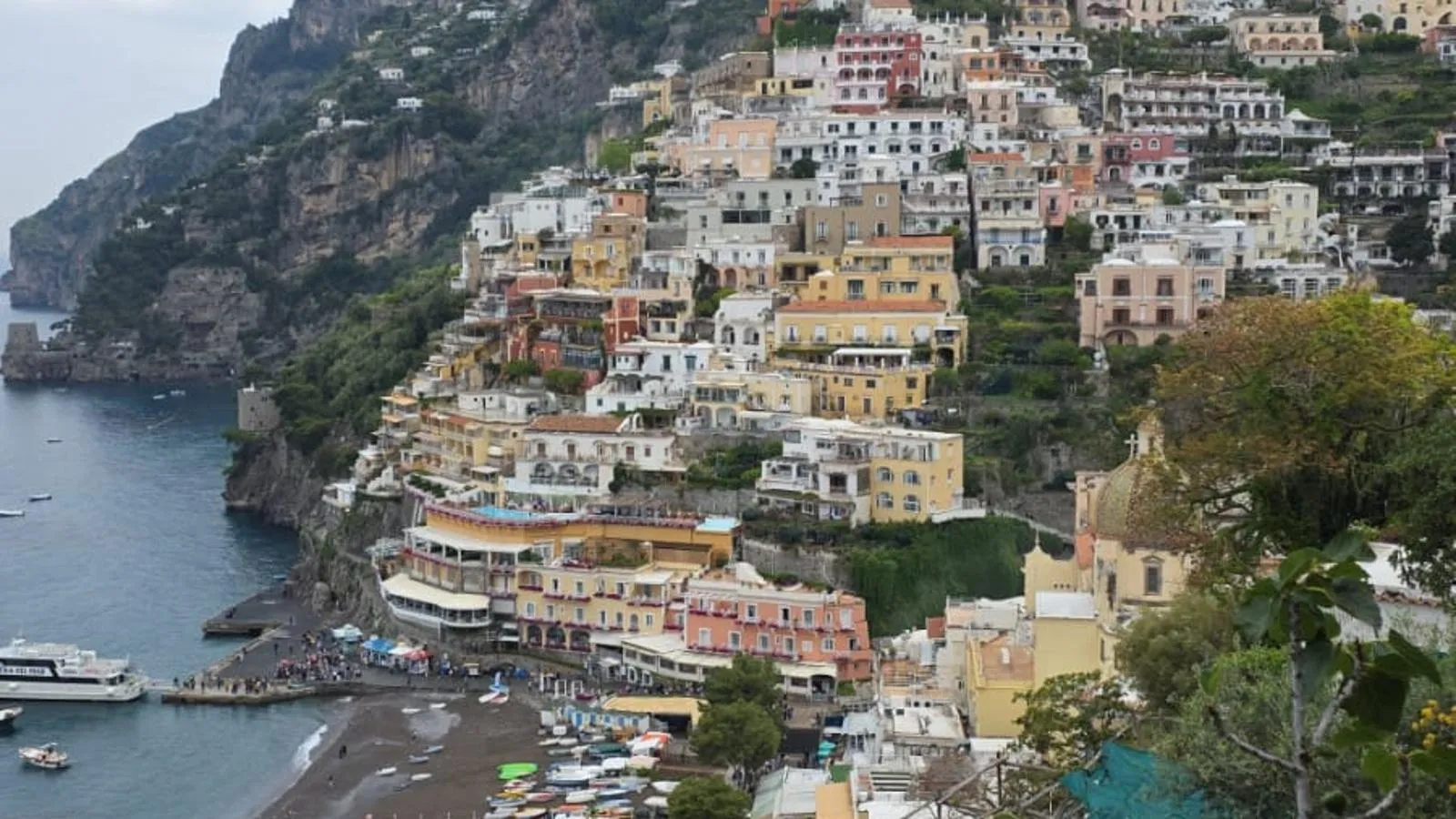 Positano's houses climbing the cliff above the beach and the blue sea